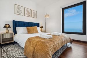 a bedroom with a bed and a large window at Casa Afonso Bay Views & Outdoor Living in Funchal