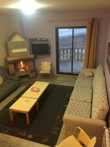 a living room with a couch and a fireplace at Stone Chalets in Fārayyā