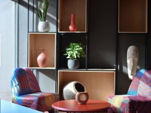 a living room with two chairs and a table at Ibis Styles Abidjan Plateau in Abidjan +103 photos