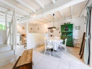 a dining room with a table and a green cabinet at Holiday Home Saint-Laurent Pool Retreat in La Chapelle-Thémer