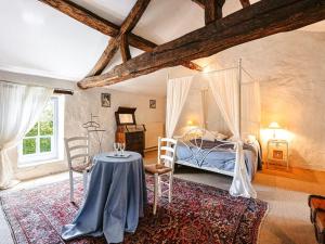 a bedroom with a bed and a table and chairs at Holiday Home Saint-Laurent Pool Retreat in La Chapelle-Thémer