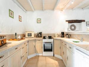 a kitchen with white cabinets and a stove top oven at Holiday Home Saint-Laurent Pool Retreat in La Chapelle-Thémer