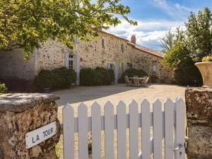 a white picket fence in front of a house at Holiday Home Saint-Laurent Pool Retreat in La Chapelle-Thémer +23 photos