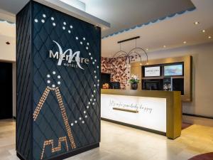 a store with a sign on the wall in a lobby at Mercure Wien Zentrum in Vienna