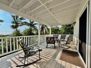 a porch with two chairs and a table on it at Bears' Place Guest House in Kailua-Kona