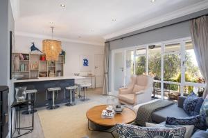 a living room with a couch and a table at Quiet Garden Flat Near Kenilworth Centre in Cape Town