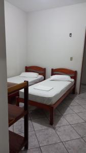 two beds are sitting in a room at Hotel Amaro in Luis Correia