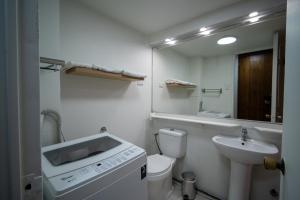 a white bathroom with a sink and a toilet at Departamentos Providencia J&M in Santiago +116 photos