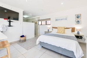 a bedroom with a bed and a television in it at Coast Unit 5, Bright Escape By Langebaan Lagoon in Langebaan