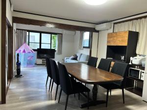 a dining room with a wooden table and chairs at ASO Uchinomaki Stay in Aso