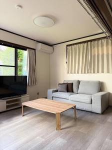 a living room with a couch and a coffee table at ASO Uchinomaki Stay in Aso