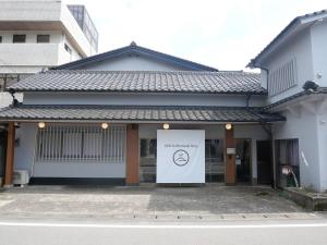 a building with a sign in front of it at ASO Uchinomaki Stay in Aso