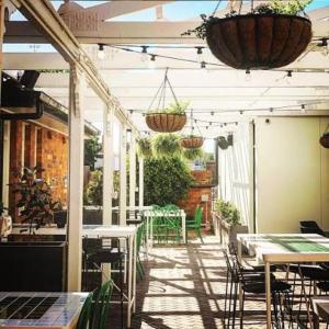 an outdoor patio with tables and chairs and plants at The Gunnedah Hotel in Gunnedah