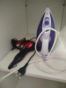 a hair dryer and an umbrella on a shelf at Casa com Ar-Condicionado in Formosa