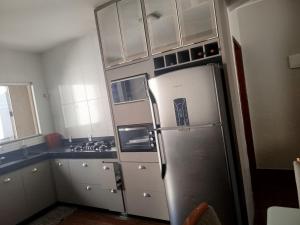 a kitchen with white cabinets and a refrigerator at Casa com Ar-Condicionado in Formosa