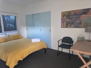 a bedroom with a bed and a desk and a chair at Zeally Bay Stay Deep Ocean in Torquay