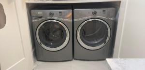 a washing machine and a washer and dryer in a room at Sunnywood Garden in Richmond