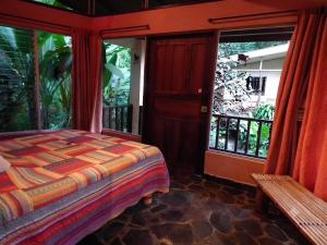 a bedroom with a bed and a balcony at Heliconia Island Lodge in Puerto Viejo +20 photos
