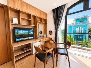 a dining room with a table and a tv and a window at Apple Phu Quoc Hotel & Restaurant in Phú Quốc