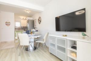a living room with a table and chairs and a tv at Gea Maris Apartment in Kaštela