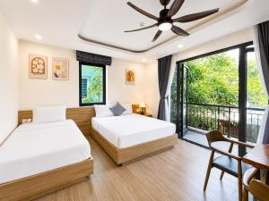 a bedroom with two beds and a balcony at Apple Phu Quoc Hotel & Restaurant in Phú Quốc