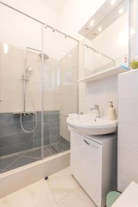 a bathroom with a glass shower and a sink at Gea Maris Apartment in Kaštela +17 photos