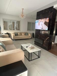 a living room with a fireplace and a tv in it at Maison dar allouche in Kelibia +8 photos
