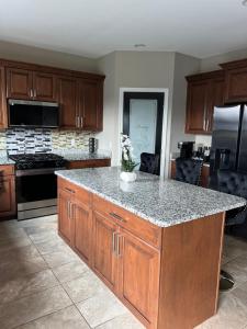 a kitchen with wooden cabinets and a granite counter top at Sterling Heights Retreat ! in Sterling Heights