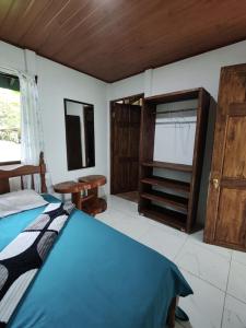 a bedroom with a bed and some wooden cabinets at Cabinas Toucan in Chachagua