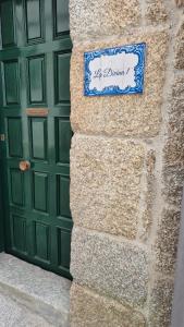 a sign on a wall next to a green door at La Divina 1 in Ribadavia +7 photos