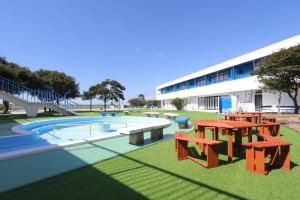 a pool with tables and benches in front of a building at 535base in Tannowa