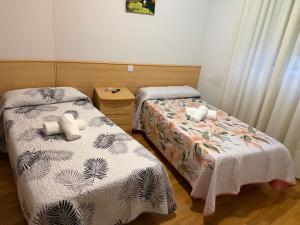 two beds in a small room at Hostal Alhambra in Mocejón