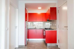 a kitchen with red cabinets and a sink at Amazing sea view in Los Cristianos in Los Cristianos