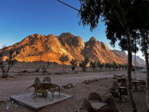 a group of tables and chairs in front of mountains at قمه التجلي in Saint Catherine