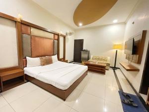a bedroom with a bed and a television in it at The Grand Hotel Multan in Multan