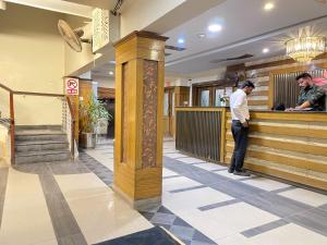 a man standing at the counter of a restaurant at The Grand Hotel Multan in Multan