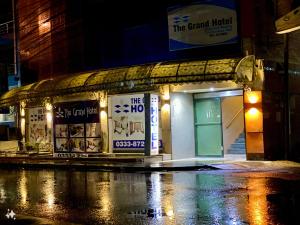 a building on the side of a street at night at The Grand Hotel Multan in Multan