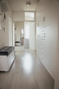a large white room with a bed and a hallway at T&M Apartman in Paraćin