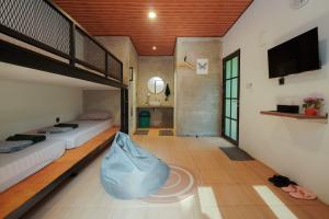 a bedroom with two bunk beds and a tv at Mariposa Cabin in Lembang