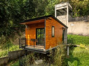 a tiny house on a platform in a field at Mariposa Cabin in Lembang