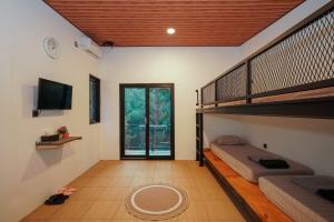 a room with two bunk beds and a television at Mariposa Cabin in Lembang