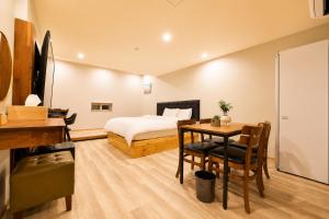 a bedroom with a bed and a table with a bed and a desk at 경산 에비앙 호텔 in Uksu +23 photos