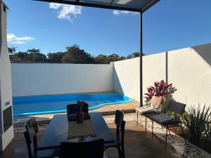 a patio with a table and chairs and a swimming pool at Casa Guimarães II in Chapada dos Guimarães