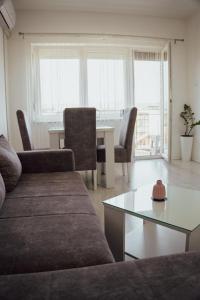 a living room with a couch and a table with chairs at T&M Apartman in Paraćin