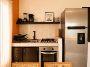 a kitchen with a sink and a refrigerator at La Aurora Puerto Escondido in Puerto Escondido