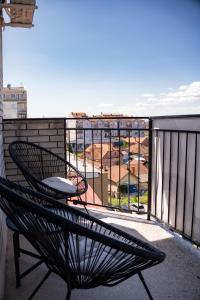 a chair on a balcony with a view of a city at T&M Apartman in Paraćin