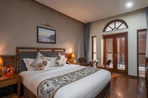 a bedroom with a large bed in a room at Canvas Sapa Legend Hotel in Sapa +73 photos