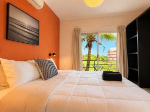 a bedroom with a large bed with an orange wall at La Aurora Puerto Escondido in Puerto Escondido