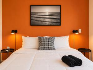 a bedroom with a bed with an orange wall at La Aurora Puerto Escondido in Puerto Escondido +56 photos