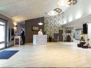 a lobby with two men standing at a counter at Novotel Manchester West in Worsley